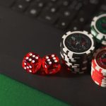 Dados e fichas sobre uma superfície de jogo, representando apostas online e jogos de azar.